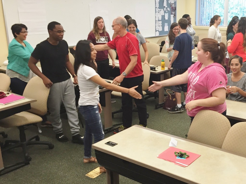 Undergraduates Kenia Aguilar and Brittany Piver prepare to shake hands.